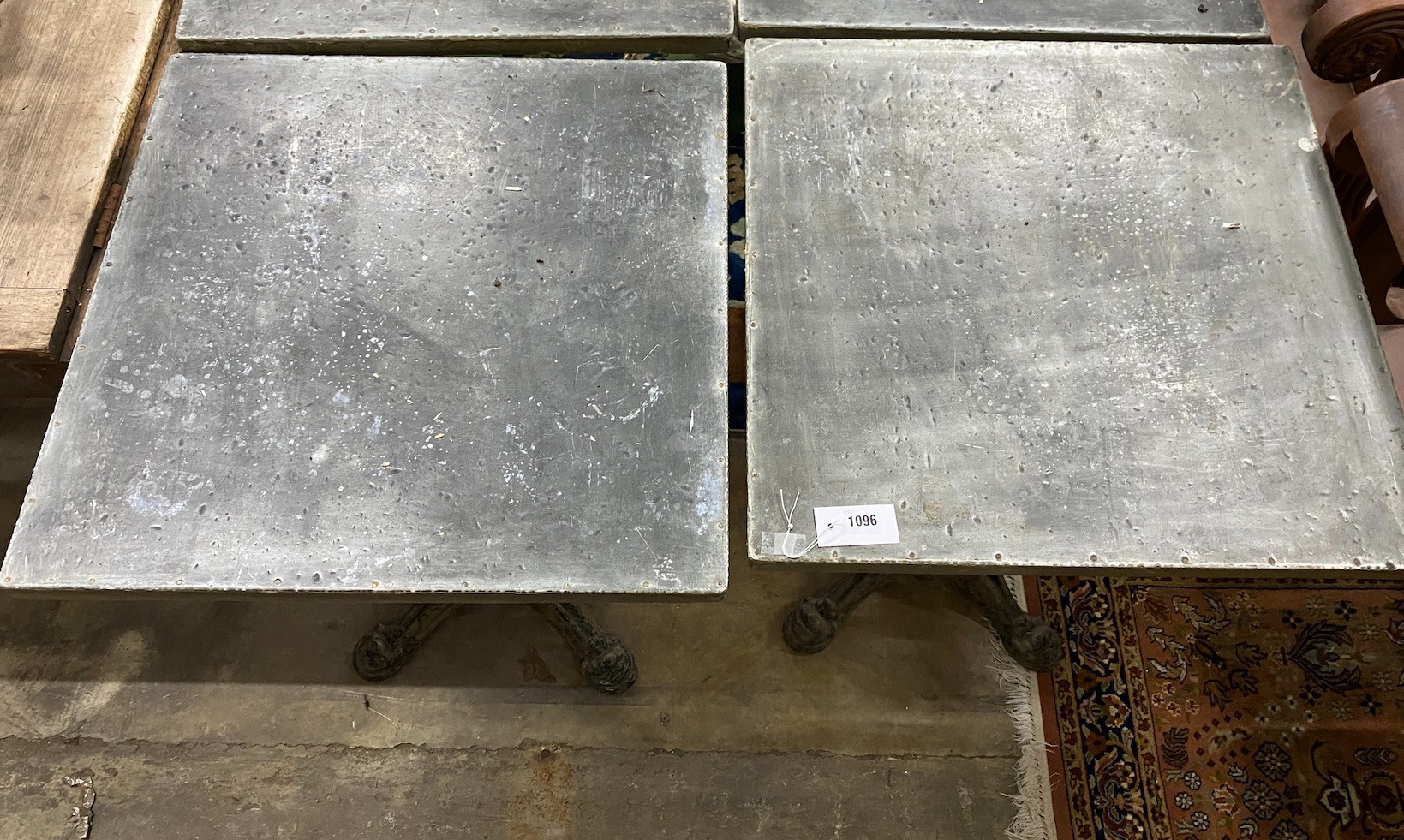 A pair of zinc top cafe tables with cast iron underframes, 60 x 60cm